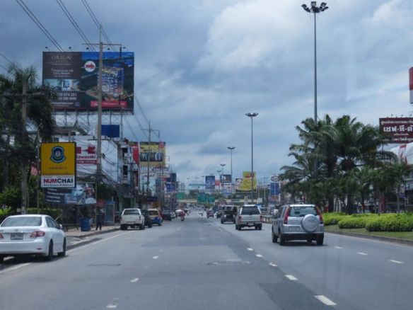 Menossa Sukhumvitin valtatietä etelään päin. Kadunvarret ovat täynnä kaikennäköistä kylttiä. Tällä isolla tiellä on jopa englanninkieliset opasteet, joita pienemmillä kaduilla ei juuri ole, ei edes katujen nimiä.