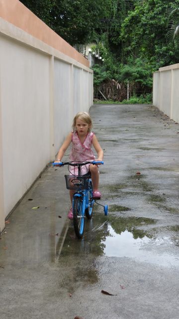 Piekku sai uuden pyörän, omalla ajotiellä on hyvä harjoitella vaikka vesisateessakin! Jospa pian pääsisimme apurattaista eroon... Ajovuoroja joutuu välillä jakamaan naapurien lasten kanssa.