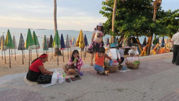Etualalla naiset päivällisellä, taustalla herrahenkilö (?) valmistautuu iltaan Pattaya Beachillä